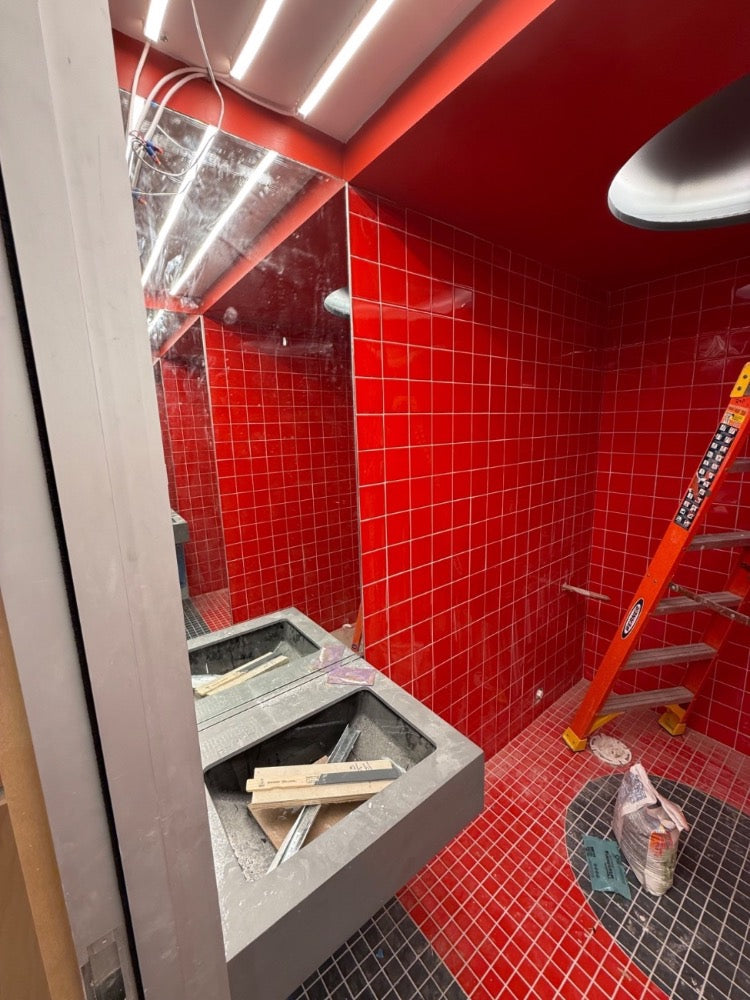 Restroom mid-construction with tile up and sinks unfinished